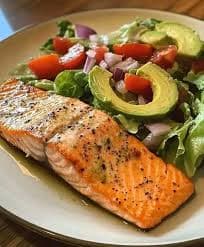 Grilled salmon, greens and avocado on a plate